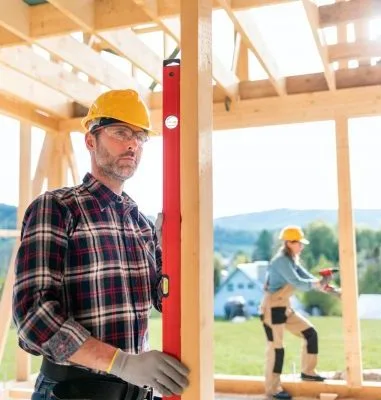 Worker measure construction on building site of frame house